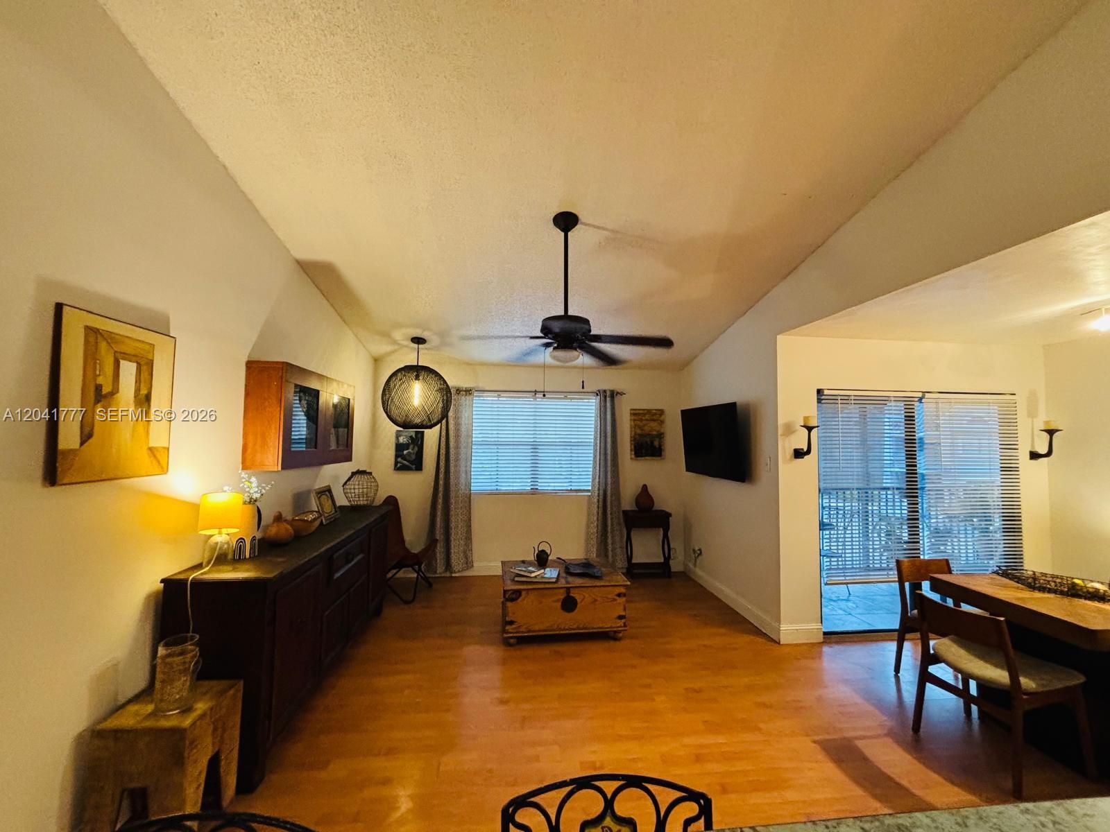 A living room with hardwood floors, a ceiling fan, and a wooden coffee table — 15050 SW 103rd Ter # 7202, Miami FL 33196, MIAMI, FL