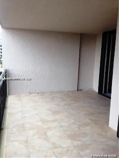 A covered balcony with light-colored tile flooring and a black metal railing — 540 Brickell Key Dr # 603, Miami FL 33131, MIAMI, FL