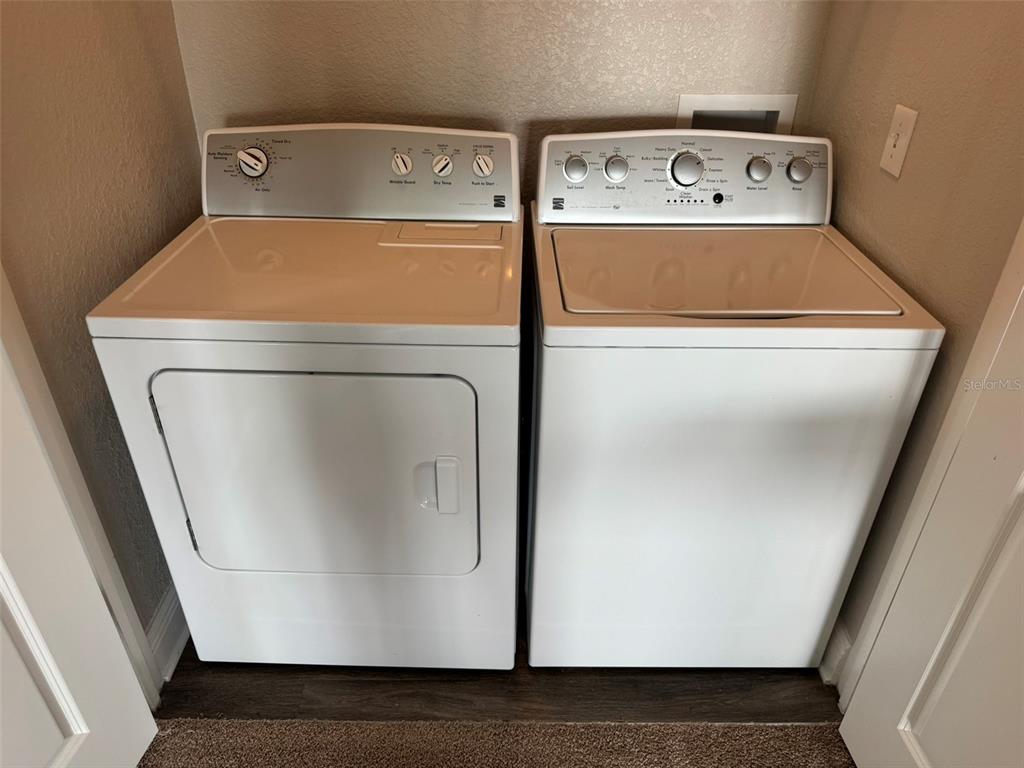 A white clothes dryer and washing machine sit side-by-side in a laundry closet — 2420 ANN ROU ROAD UNIT 201, TAVARES, FL