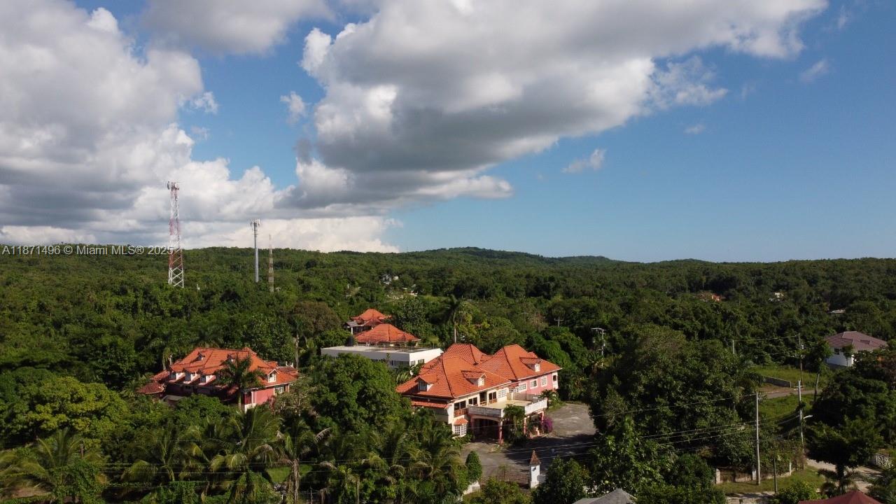 An aerial view shows two large houses with red tile roofs surrounded by dense forest — Summerset Negril, Jamaica, NA, NA