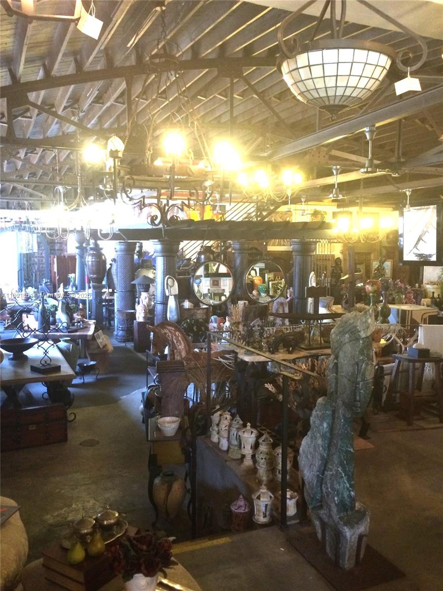 An interior view of a cluttered antique shop featuring various sculptures, furniture, and hanging chandeliers — 101 NE 1st St, Dania Beach FL 33004, DANIA BEACH, FL