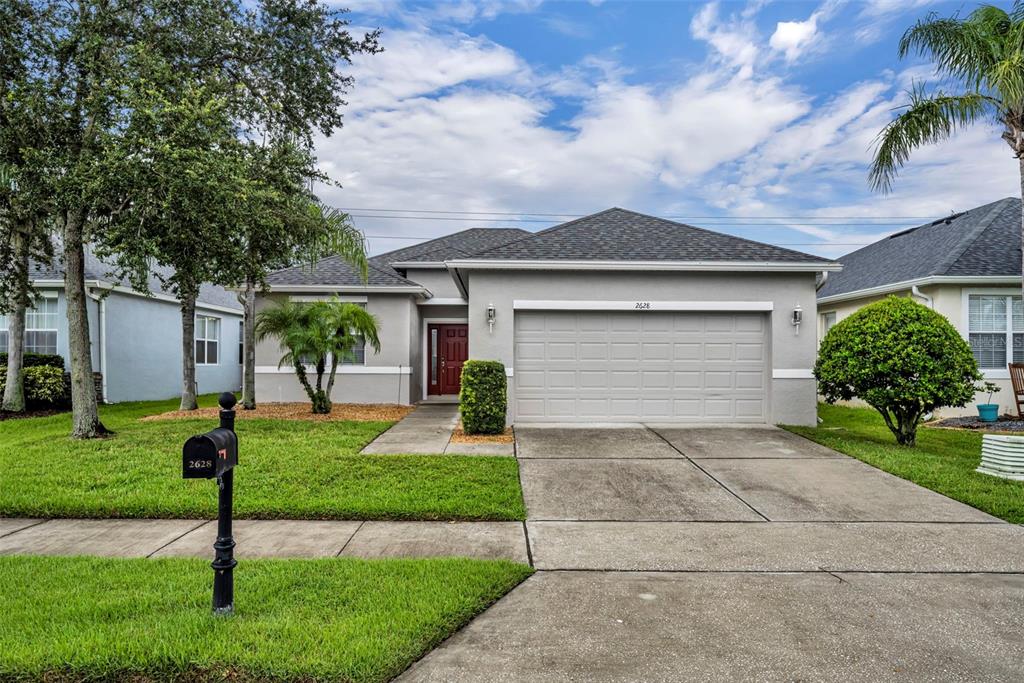 A single-story house with a gray exterior, a two-car garage, and a red front door — 2628 BALFORN TOWER WAY, WINTER GARDEN, FL