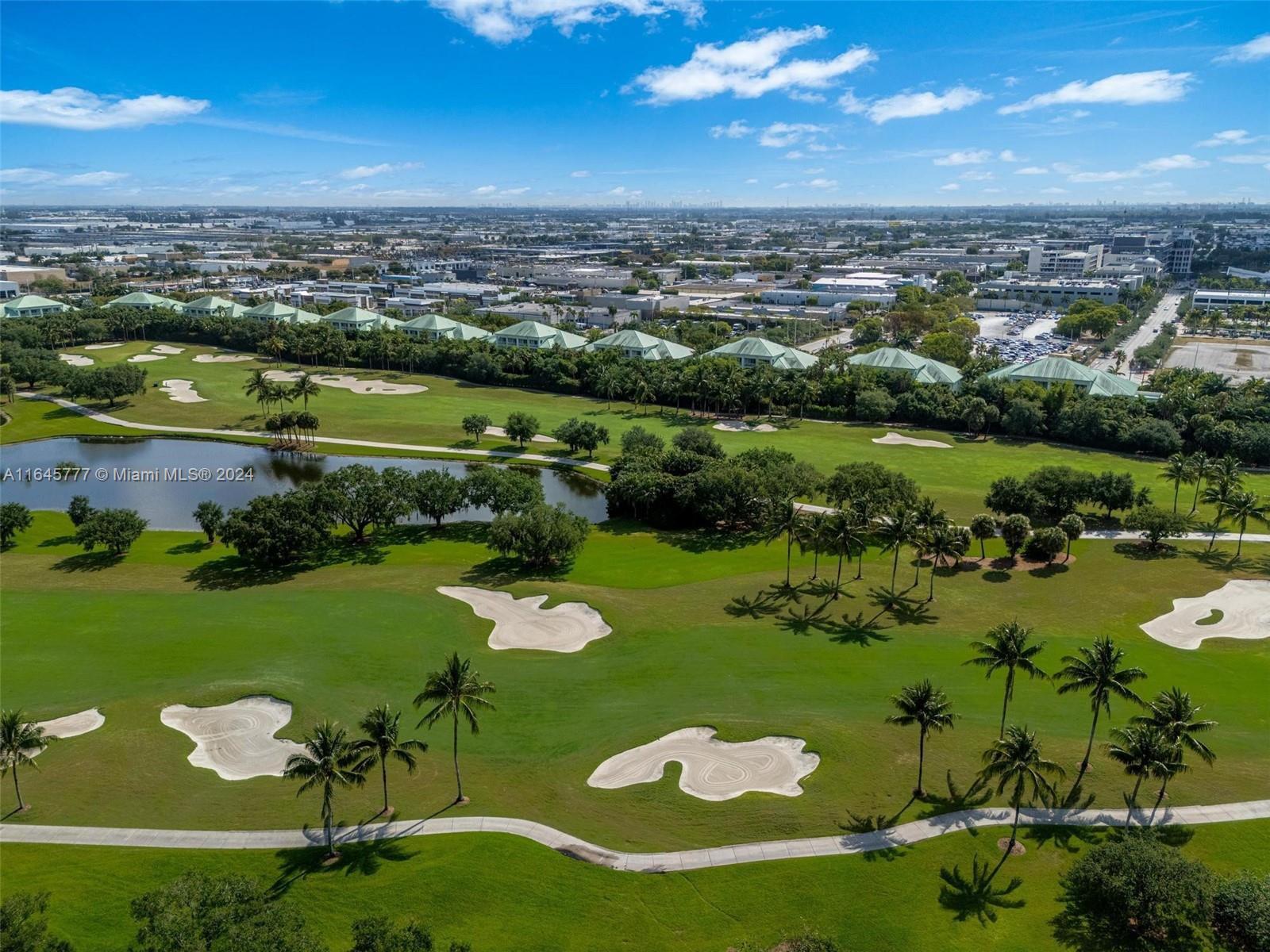 An aerial view shows a golf course with sand traps, a pond, and residential buildings — 5300 NW 87th Ave # 1308, Doral FL 33178, DORAL, FL