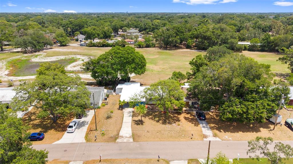 A covered carport features a gray floor, blue and tan siding, and two blue doors — 10221 N FLEETWOOD DRIVE, TAMPA, FL