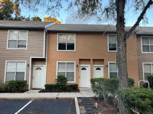 A multi-unit townhouse building with tan stucco and brown siding exteriors under a cloudy sky — 4415 SW 34TH STREET UNIT 608, GAINESVILLE, FL
