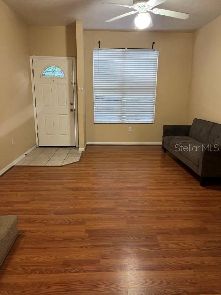 A living room features wood-look flooring, a white front door, a ceiling fan, and a sofa — 4415 SW 34TH STREET UNIT 608, GAINESVILLE, FL