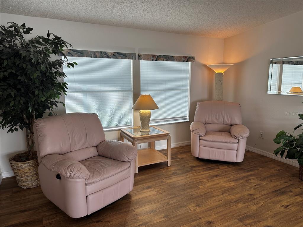 A living room features two pink leather recliners, a side table, and wood-look flooring — 502 AMBERJACK DRIVE, NORTH PORT, FL