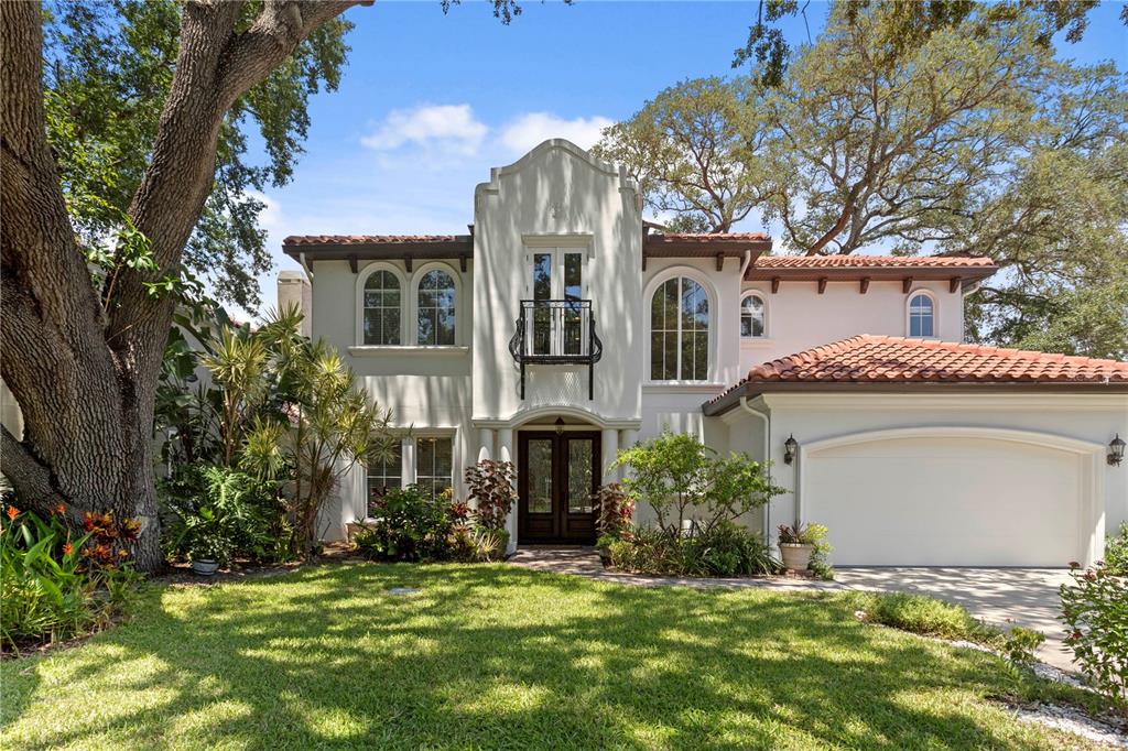 A two-story Mediterranean-style house with a stucco exterior, tile roof, and a front-facing garage — 3911 W DALE AVENUE, TAMPA, FL