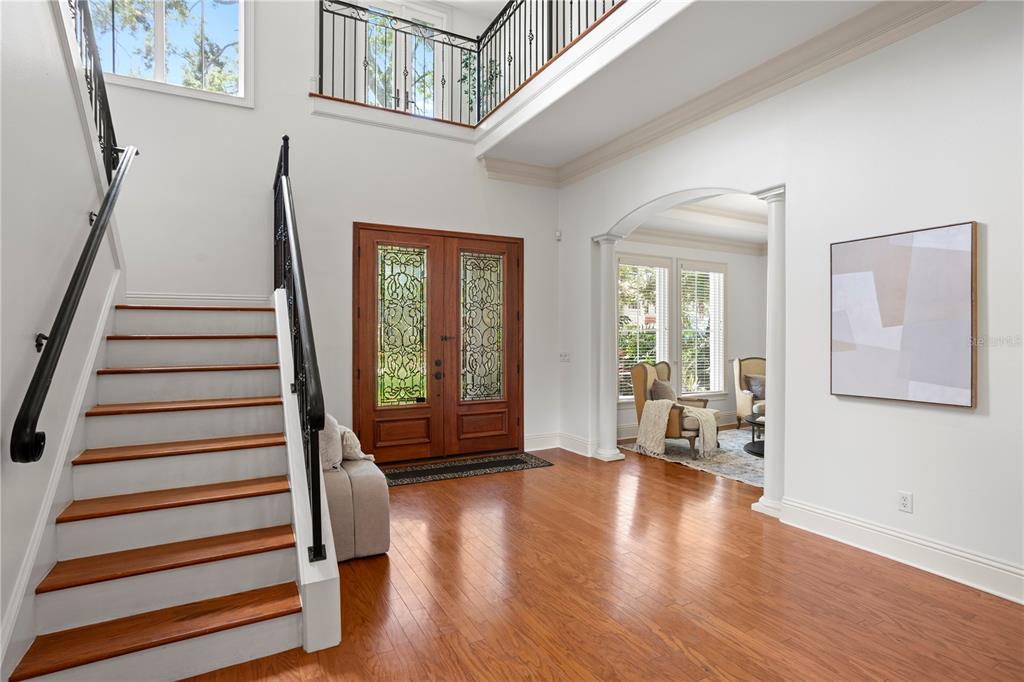A two-story foyer features hardwood floors, a wooden staircase, and an arched entryway — 3911 W DALE AVENUE, TAMPA, FL