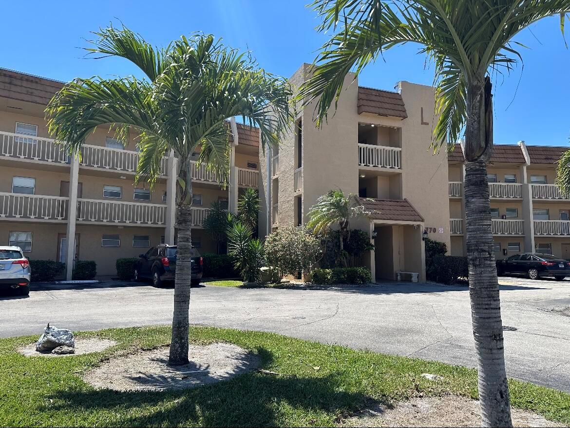 A multi-story tan apartment building with balconies and palm trees in the foreground — 6770 Royal Palm Boulevard # 207l, Margate FL 33063, MARGATE, FL