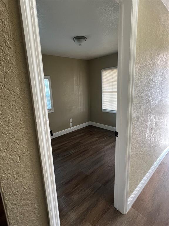 A view through a doorway into a small, empty room with wood-look flooring and blinds — 1307 W KALEY AVENUE, ORLANDO, FL