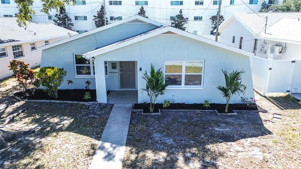 A light blue single-story house features a front walkway, landscaping, and a covered entryway — 130 42ND AVENUE N, ST PETERSBURG, FL