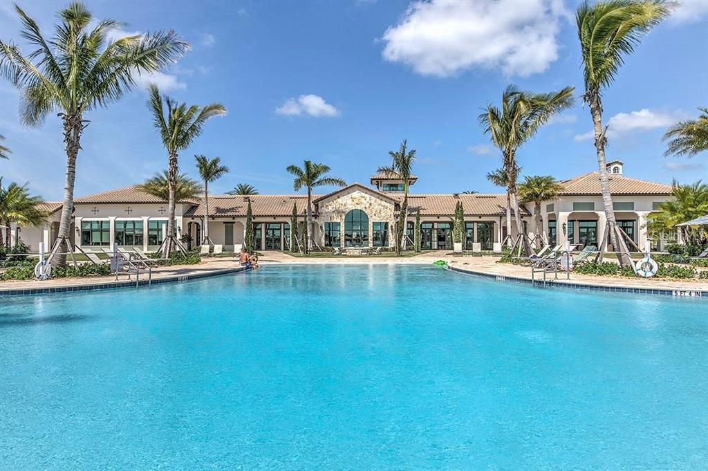 A large swimming pool sits in front of a single-story building with palm trees — 233 VINADIO BOULEVARD, NOKOMIS, FL