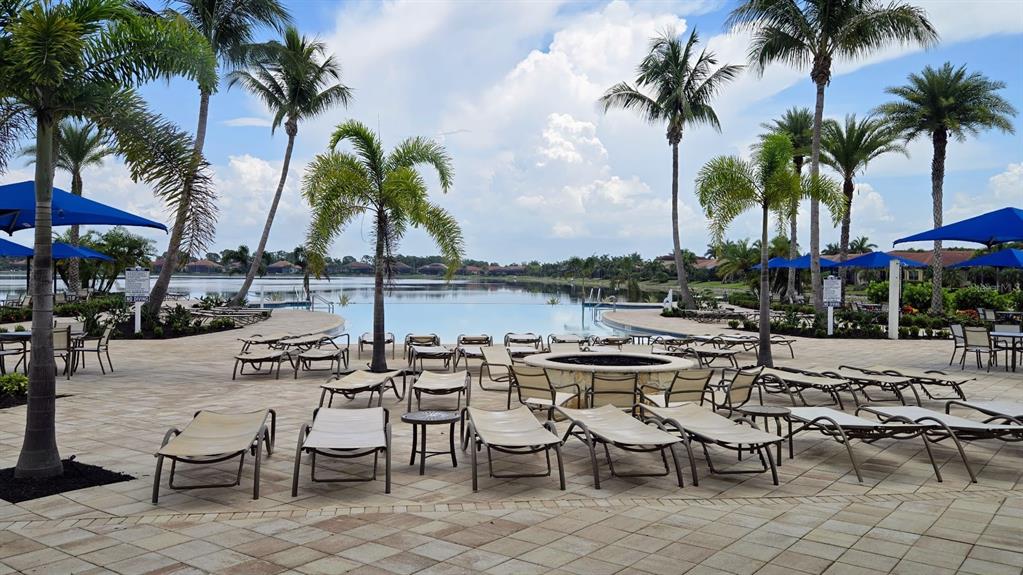 A pool deck with lounge chairs, palm trees, and a view of a lake — 233 VINADIO BOULEVARD, NOKOMIS, FL