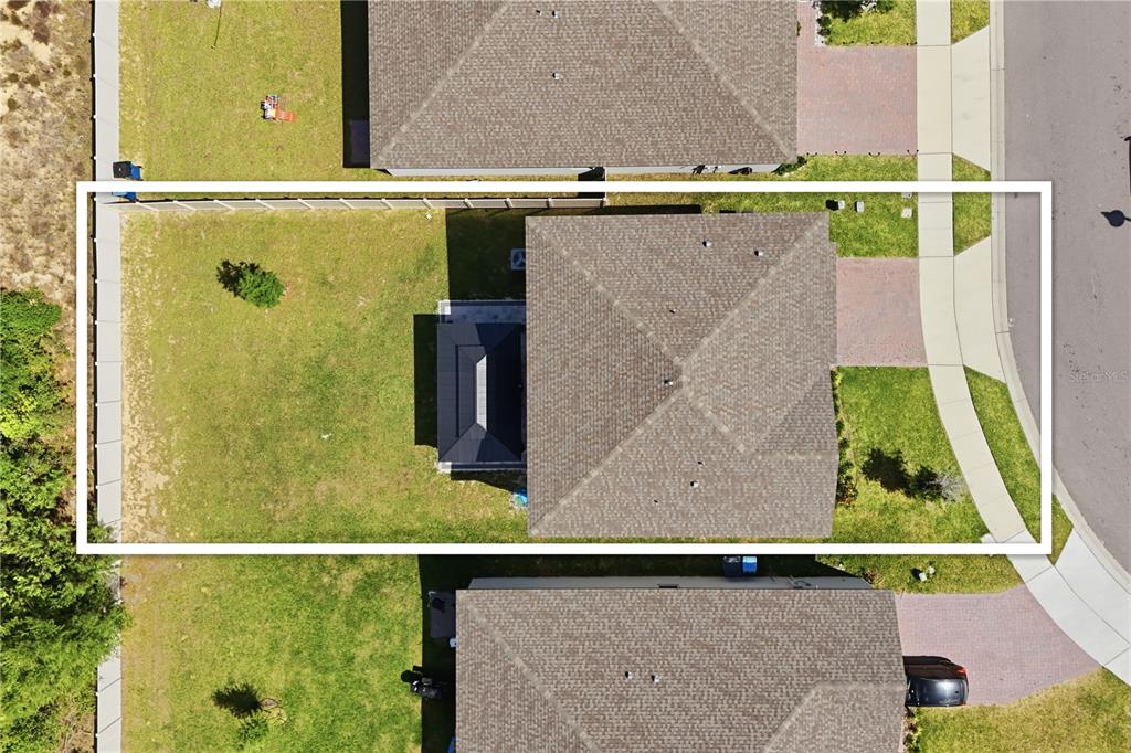 An aerial view shows a residential house with a large backyard and a paved driveway — 2424 WHITETAIL, DAVENPORT, FL