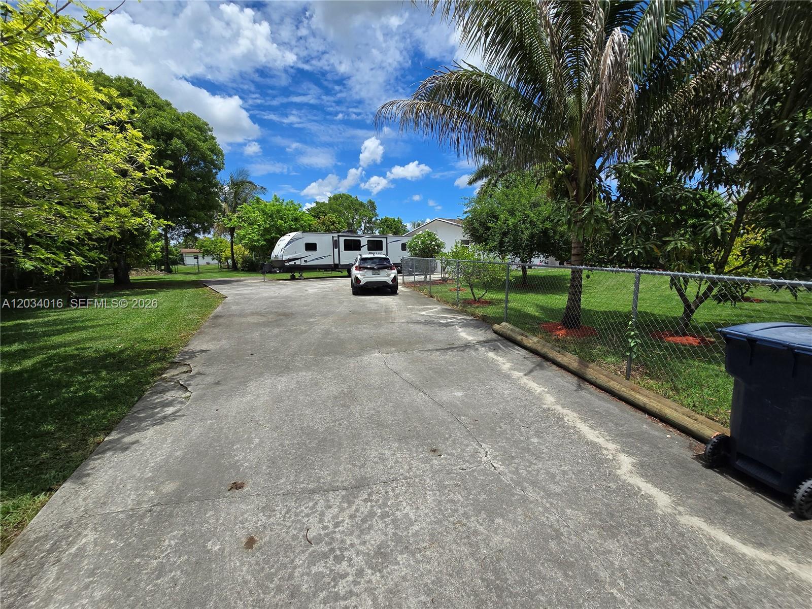 A white SUV is parked on a concrete driveway next to a travel trailer — 20595 SW 190th St, Miami FL 33187, MIAMI, FL