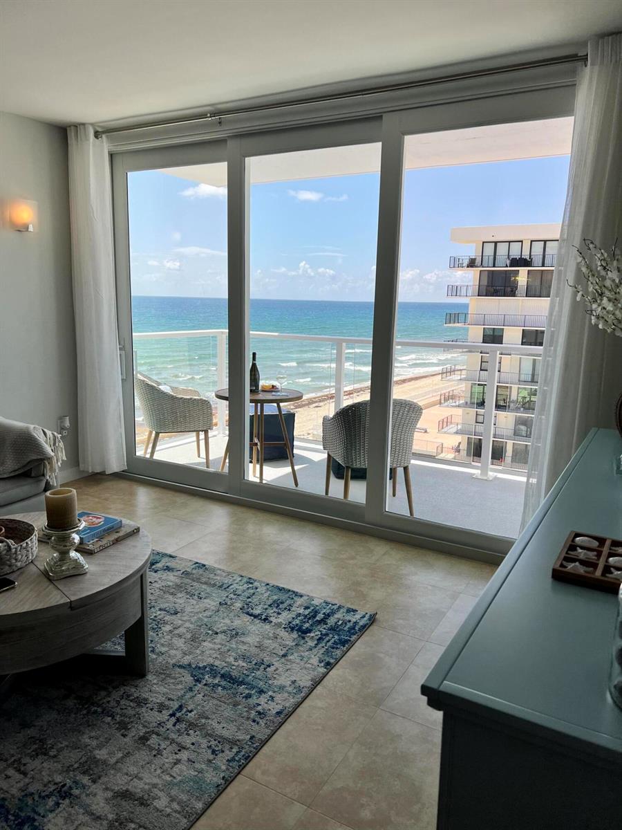 A living room with tile floors opens to a balcony overlooking the ocean and beach — 3450 S Ocean Boulevard # 610, Palm Beach FL 33480, PALM BEACH, FL