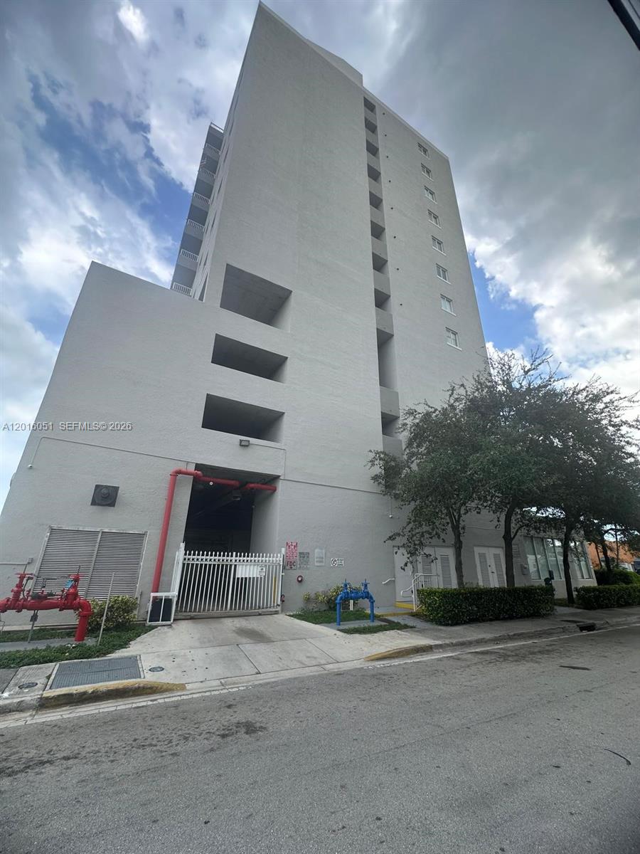 A tall, gray concrete building features an open parking garage entrance and exterior fire pipes — 2217 NW 7th St # 2, Miami FL 33125, MIAMI, FL