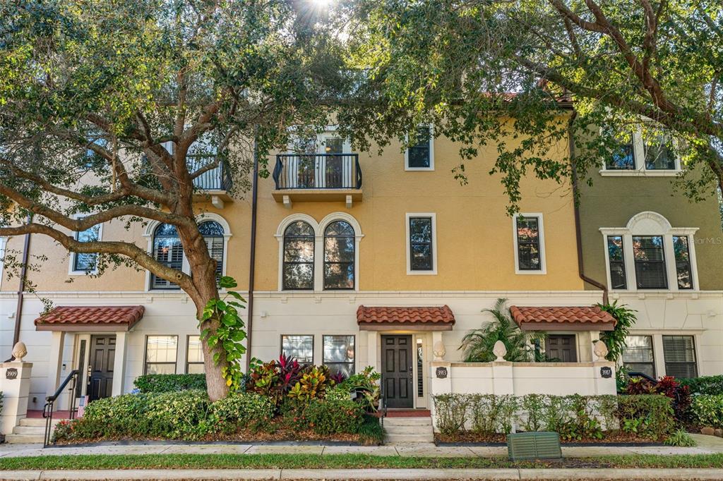 A row of three-story townhomes with stucco facades, arched windows, and small balconies — 3913 MESSINA DRIVE, LAKE MARY, FL