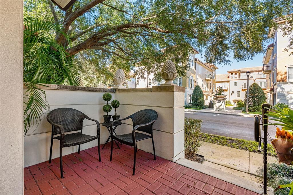 A small patio with two wicker chairs, a side table, and red brick pavers — 3913 MESSINA DRIVE, LAKE MARY, FL