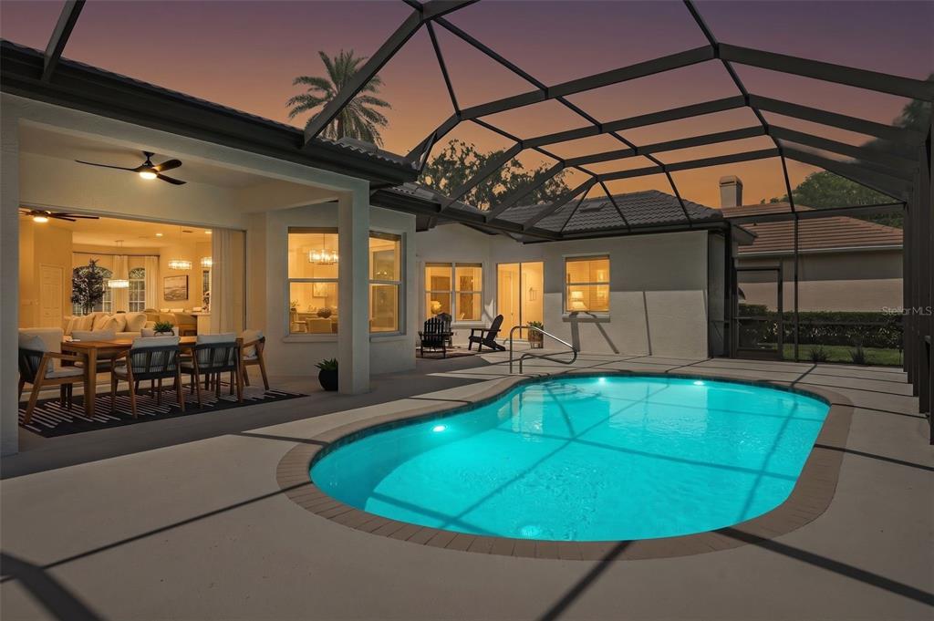 A screened-in patio features a swimming pool, outdoor dining area, and views into the home — 7318 EATON COURT, UNIVERSITY PARK, FL
