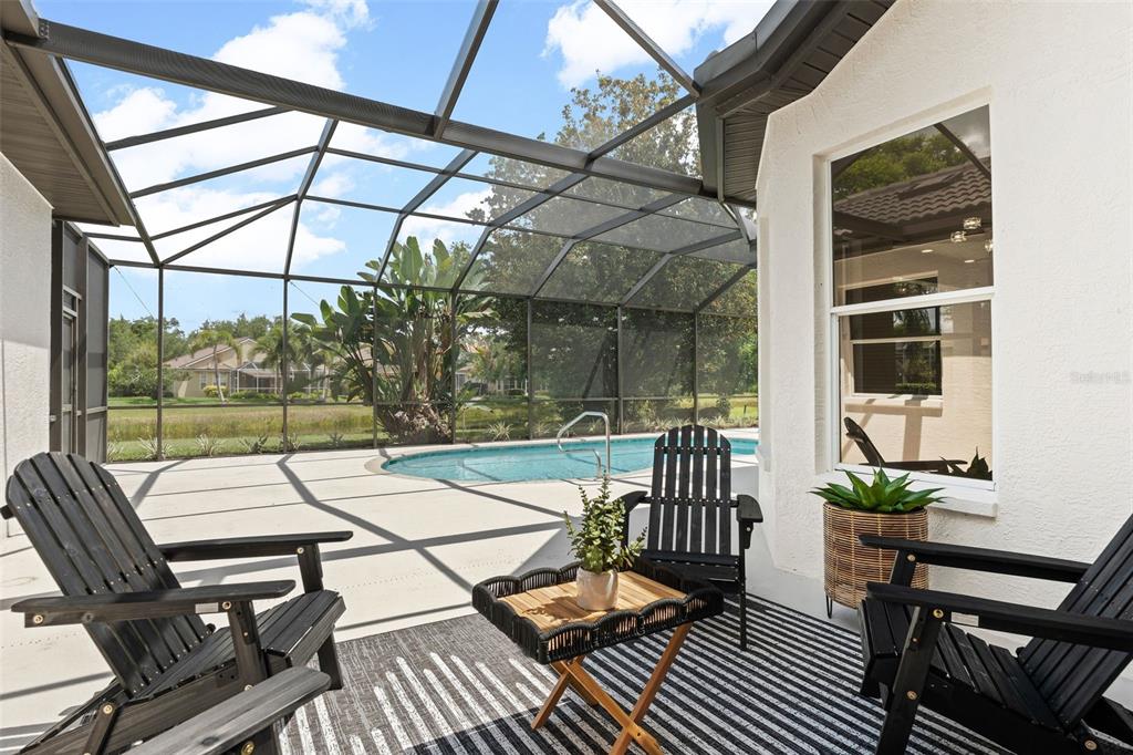 A screened-in patio features a swimming pool, outdoor furniture, and a view of the yard — 7318 EATON COURT, UNIVERSITY PARK, FL