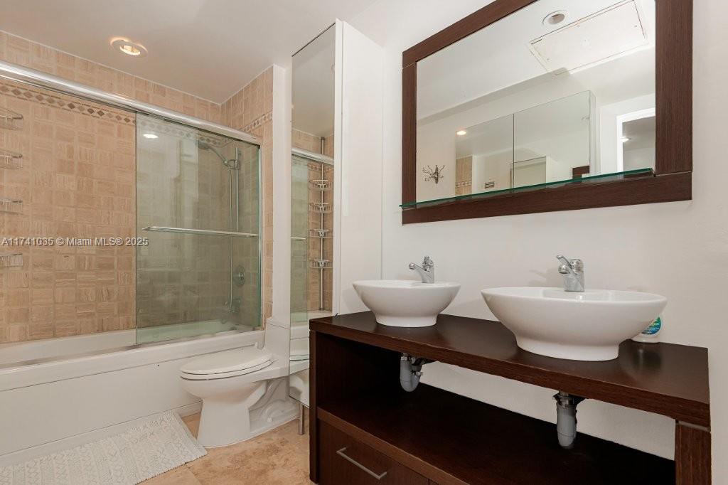 A bathroom features a double vanity with vessel sinks, a mirror, and a shower-tub combination — 2301 Collins Ave # 1629, Miami Beach FL 33139, MIAMI BEACH, FL
