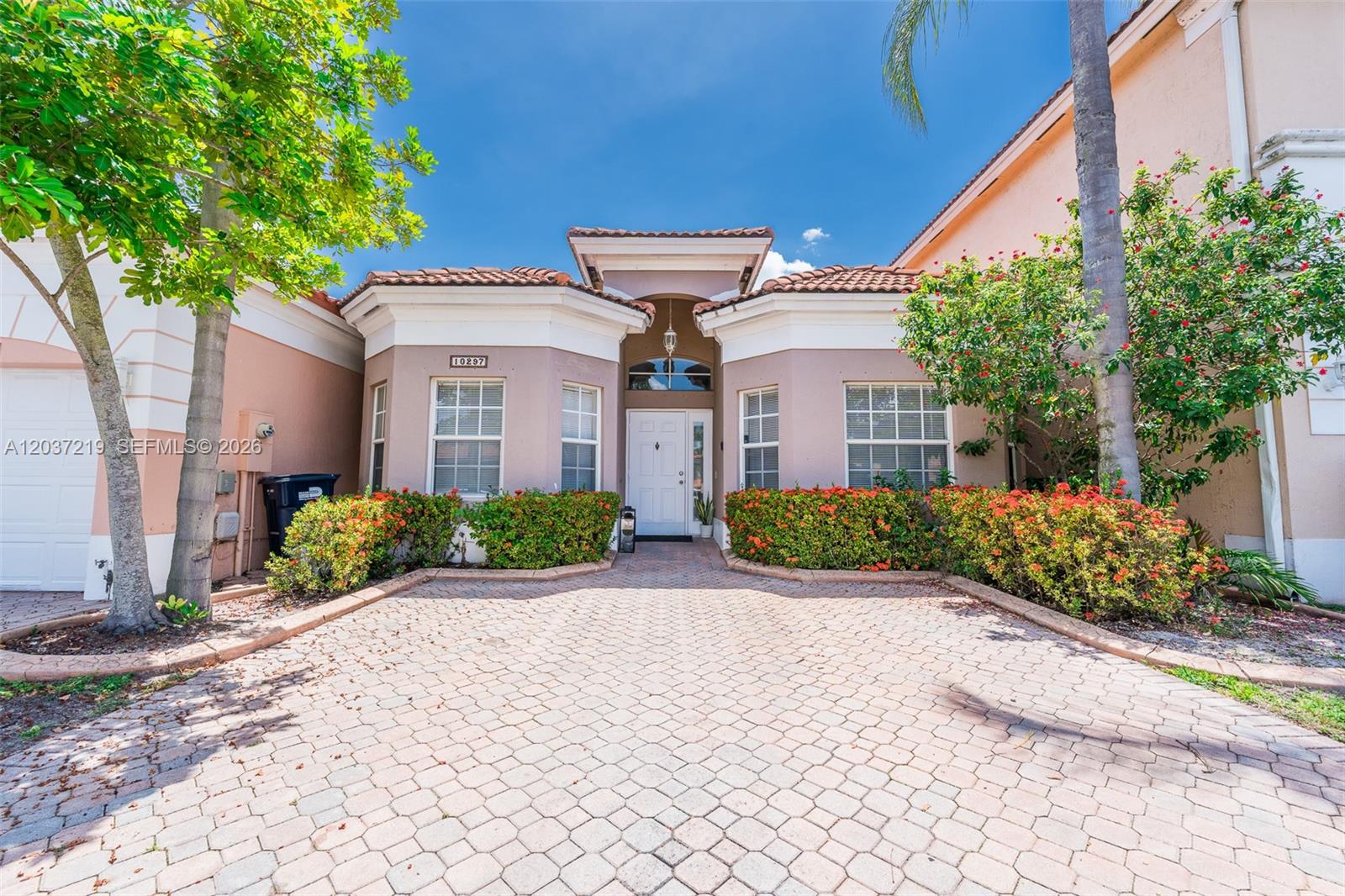 The exterior of a single-story house features a paved driveway and a front entrance — 10297 SW 162nd Ct, Miami FL 33196, MIAMI, FL