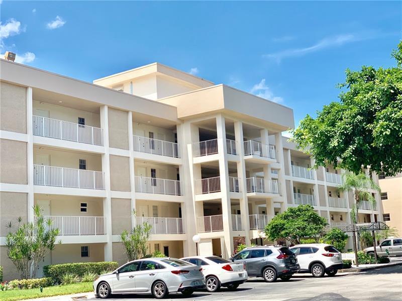 A multi-story apartment building with white balconies and a parking lot in front — 2601 S Course Drive # 203, Pompano Beach FL 33069, POMPANO BEACH, FL