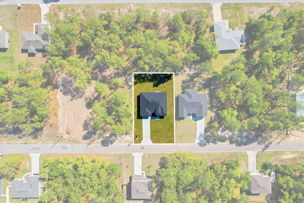 An aerial view shows a single-family home centered on a lot surrounded by trees — 9319 N CORTLANDT DRIVE, CITRUS SPRINGS, FL
