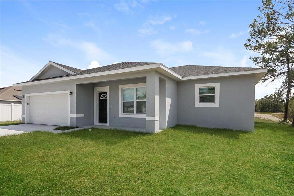 A single-story gray house with a white garage door and a front porch — 137 VIOLET CT, KISSIMMEE, FL