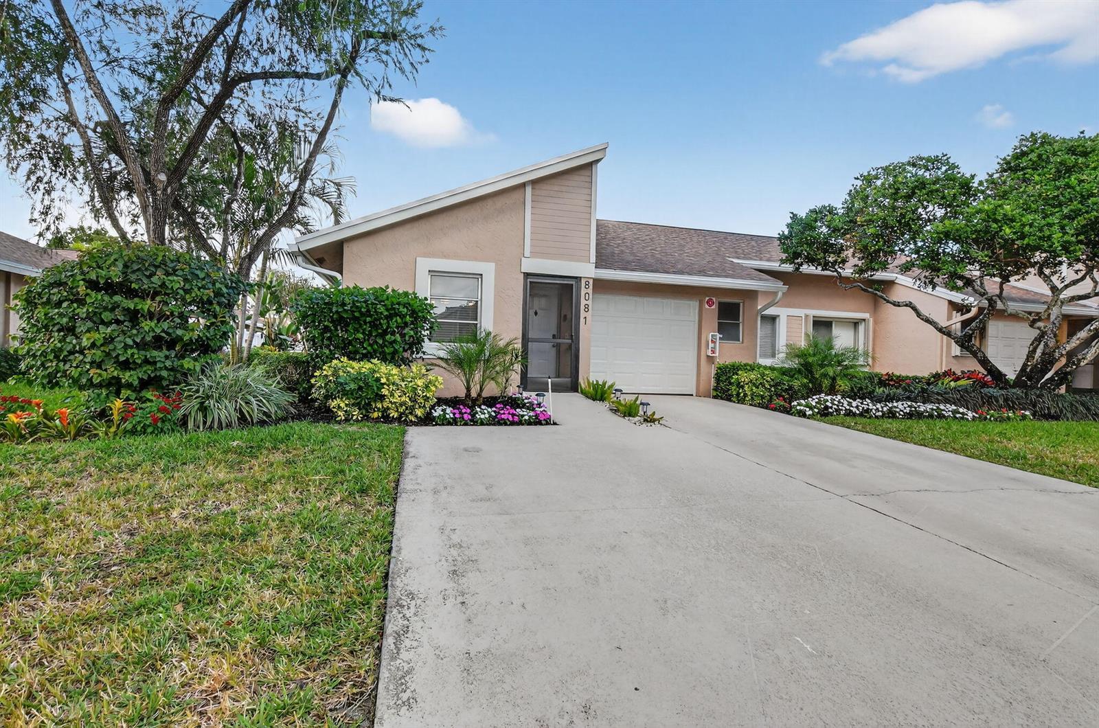 A single-story tan house with a concrete driveway, a garage, and landscaped front yard — 8081 Springtree Road, Boca Raton FL 33496, BOCA RATON, FL