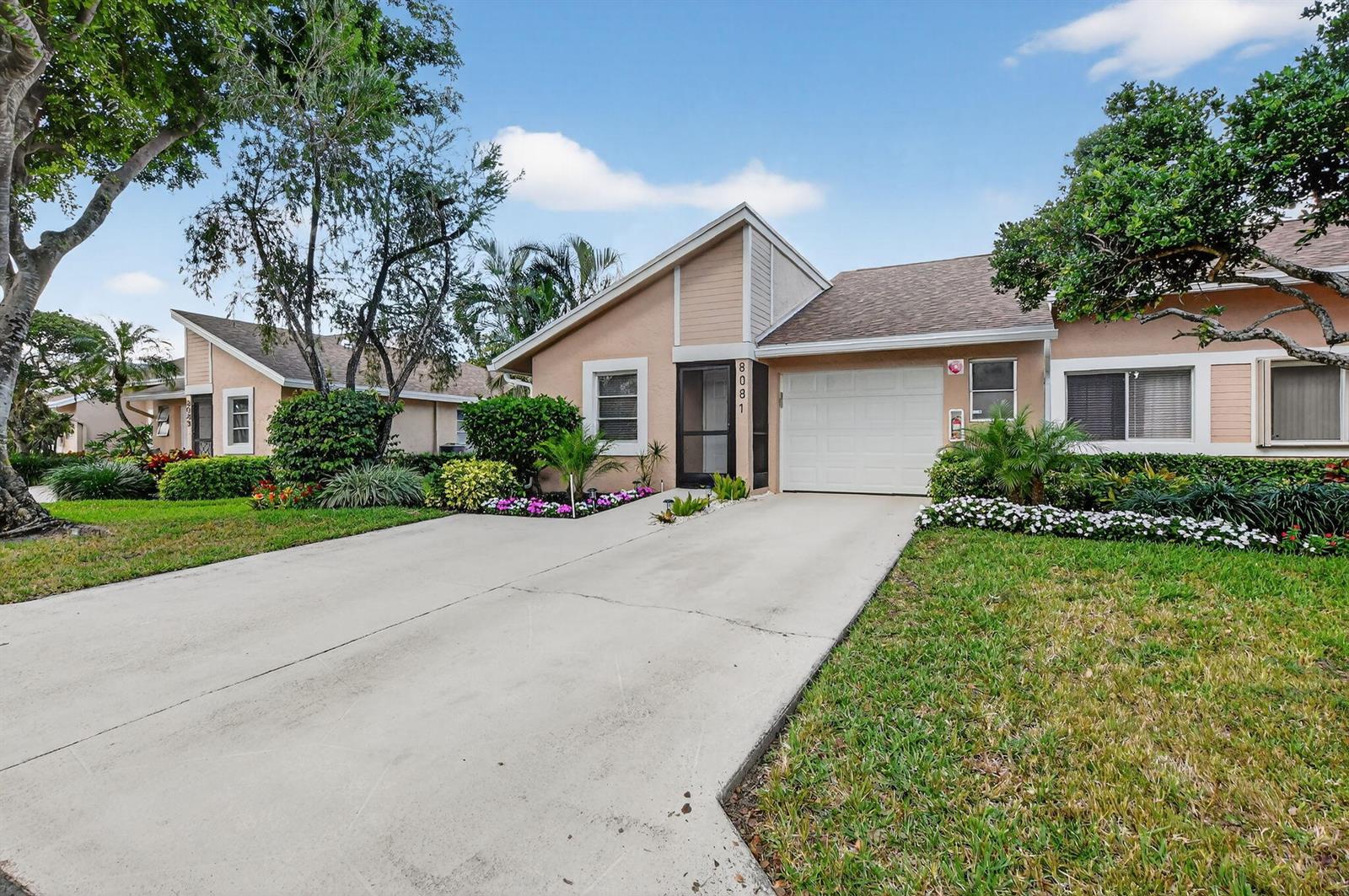 A single-story house with a beige exterior, a white garage door, and a concrete driveway — 8081 Springtree Road, Boca Raton FL 33496, BOCA RATON, FL
