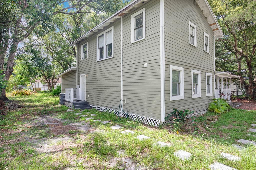 A two-story house with green horizontal siding and white trim sits on a grassy lot — 2508 YALE AVENUE, SANFORD, FL