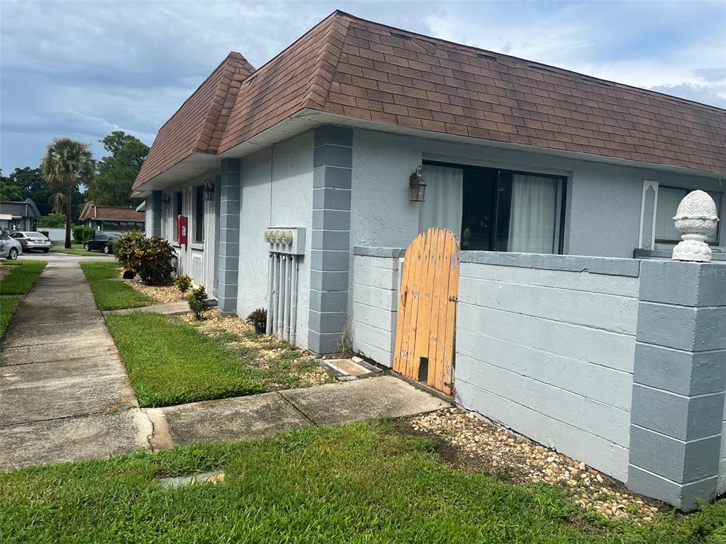 A view of the exterior of a single-story building with a brown mansard roof — 5100 70TH PLACE N UNIT 5100, PINELLAS PARK, FL