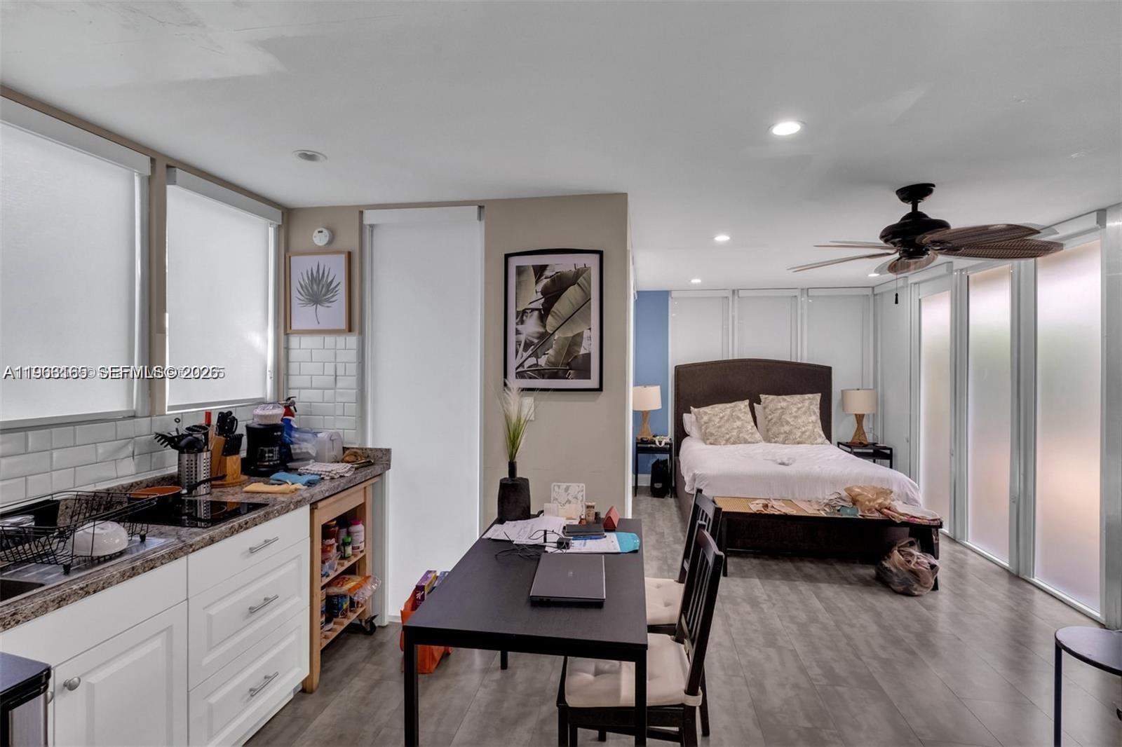 A studio apartment features a kitchen area, dining table, and a bed in one room — 1033 NW 6th St, Miami FL 33136, MIAMI, FL