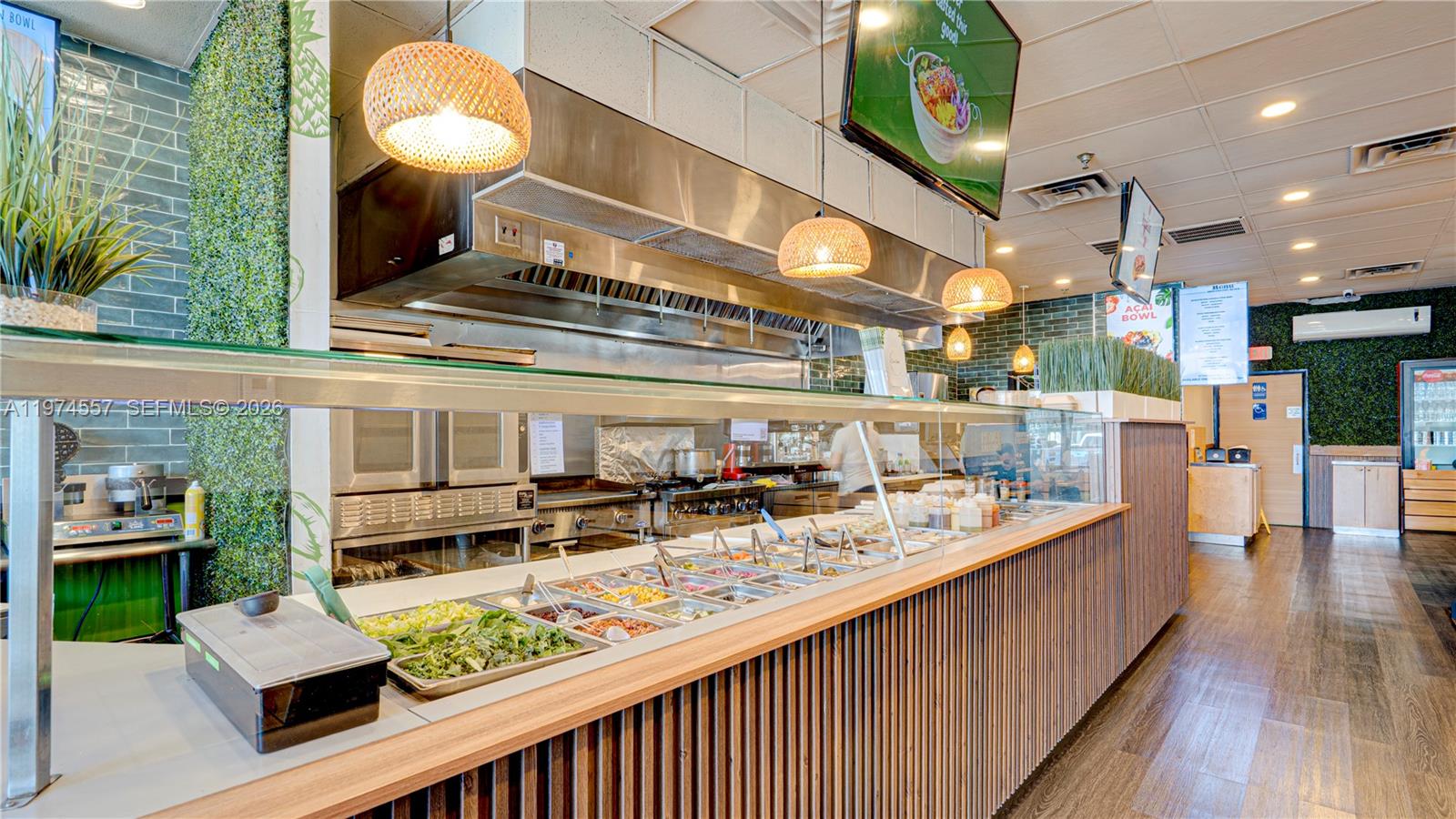 A commercial kitchen counter with food prep stations and hanging pendant lights in a restaurant — Kendall Miami, Miami FL 33193, MIAMI, FL