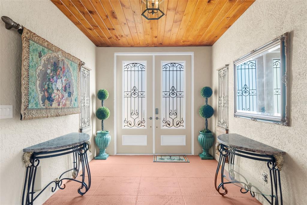 A two-story house with a tan stucco exterior, orange trim, and a paved driveway — 3805 SABA COURT, PUNTA GORDA, FL