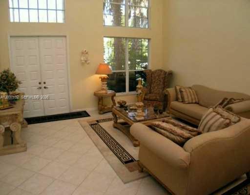 A living room with beige furniture, a patterned area rug, and tall windows — 17958 SW 36th St, Miramar FL 33029, MIRAMAR, FL