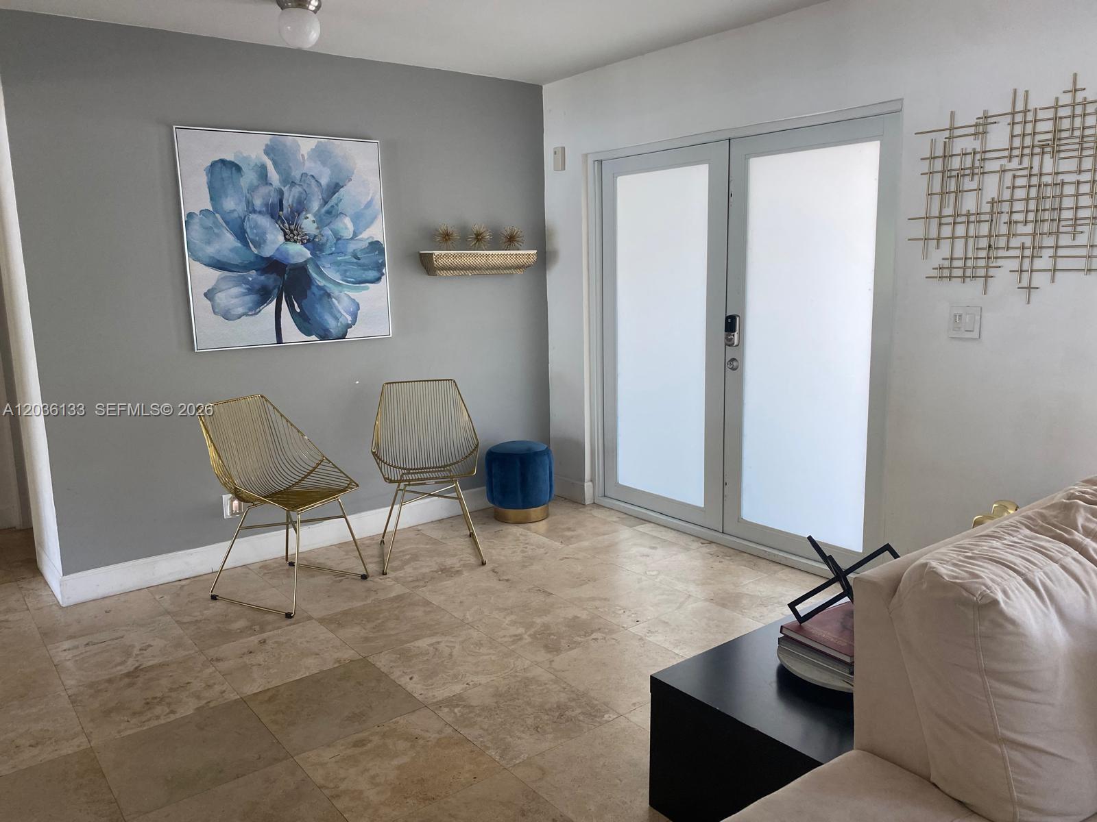 A living area features a gray accent wall, two gold wire chairs, and tile flooring — 1103 Washington St, Hollywood FL 33019, HOLLYWOOD, FL