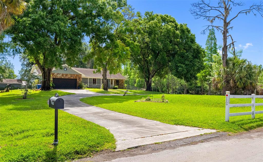 A single-story house with a stone facade and a concrete driveway sits on a lawn — 11109 WINN ROAD, RIVERVIEW, FL