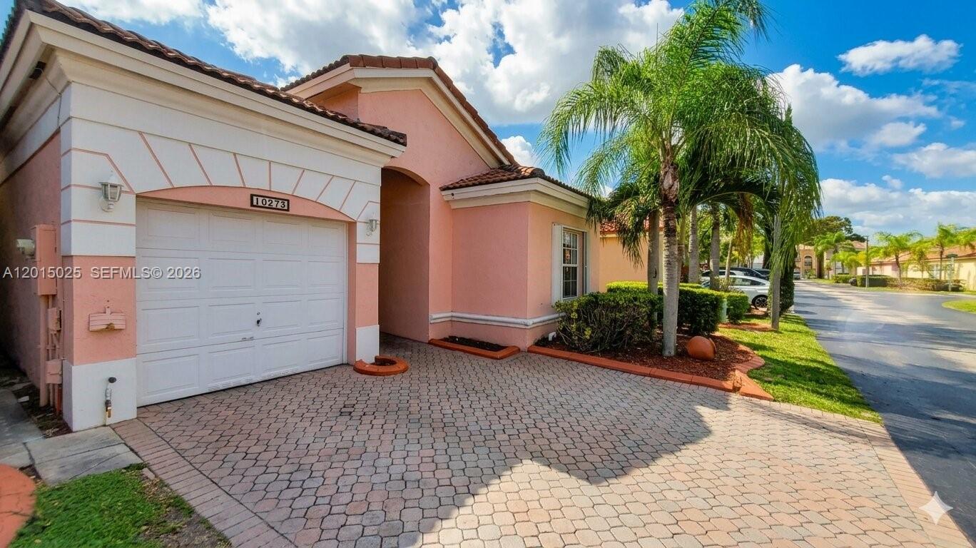 A pink stucco house with a white garage door and a paved driveway — 10273 SW 162nd Ct, Miami FL 33196, MIAMI, FL