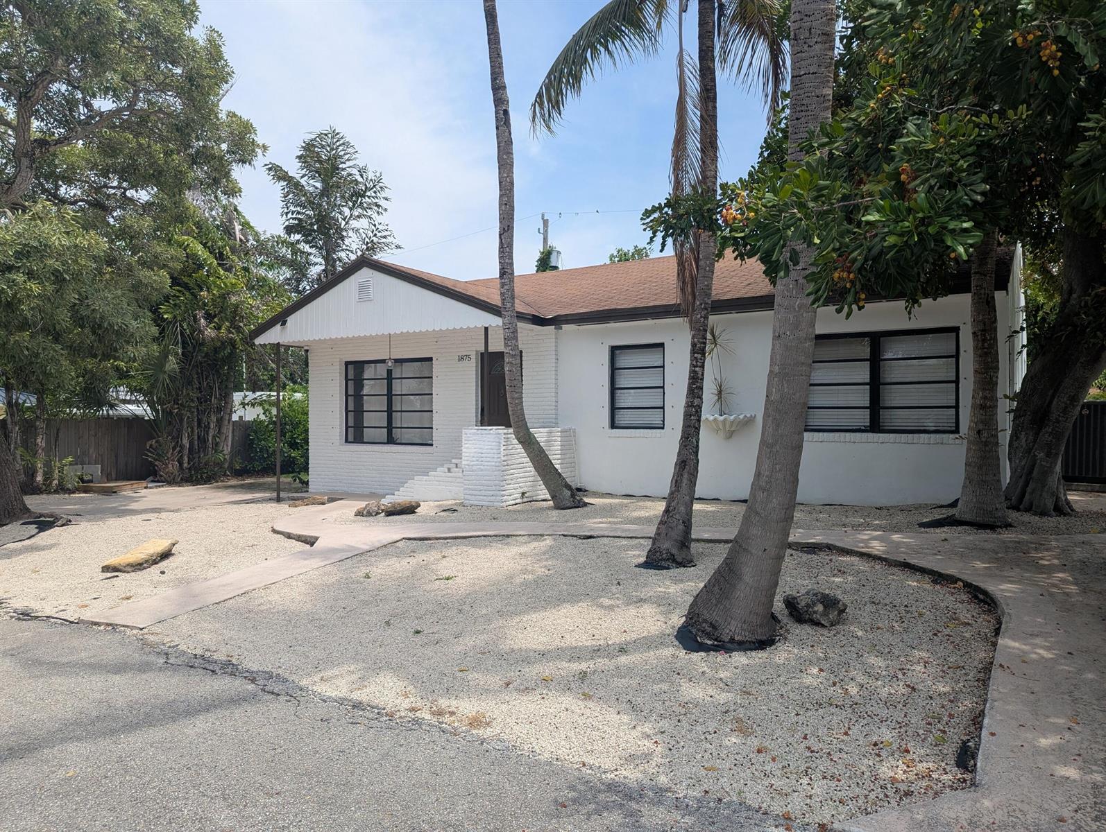 An aerial view shows a single-story house with a brown roof and a landscaped yard — 1875 Ridge Road, Juno Beach FL 33408, JUNO BEACH, FL