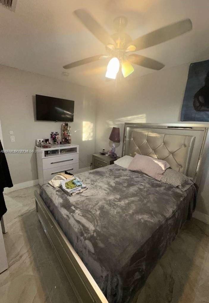 A bedroom features a tufted headboard, a ceiling fan, and a white dresser with a television — 28407 SW 129th Pl, Homestead FL 33033, HOMESTEAD, FL