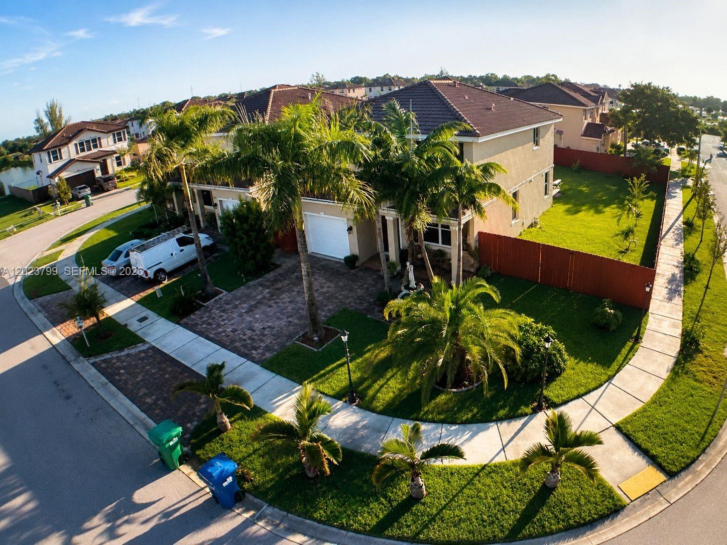 An aerial view of a two-story suburban house with a paved driveway and palm trees — 28407 SW 129th Pl, Homestead FL 33033, HOMESTEAD, FL