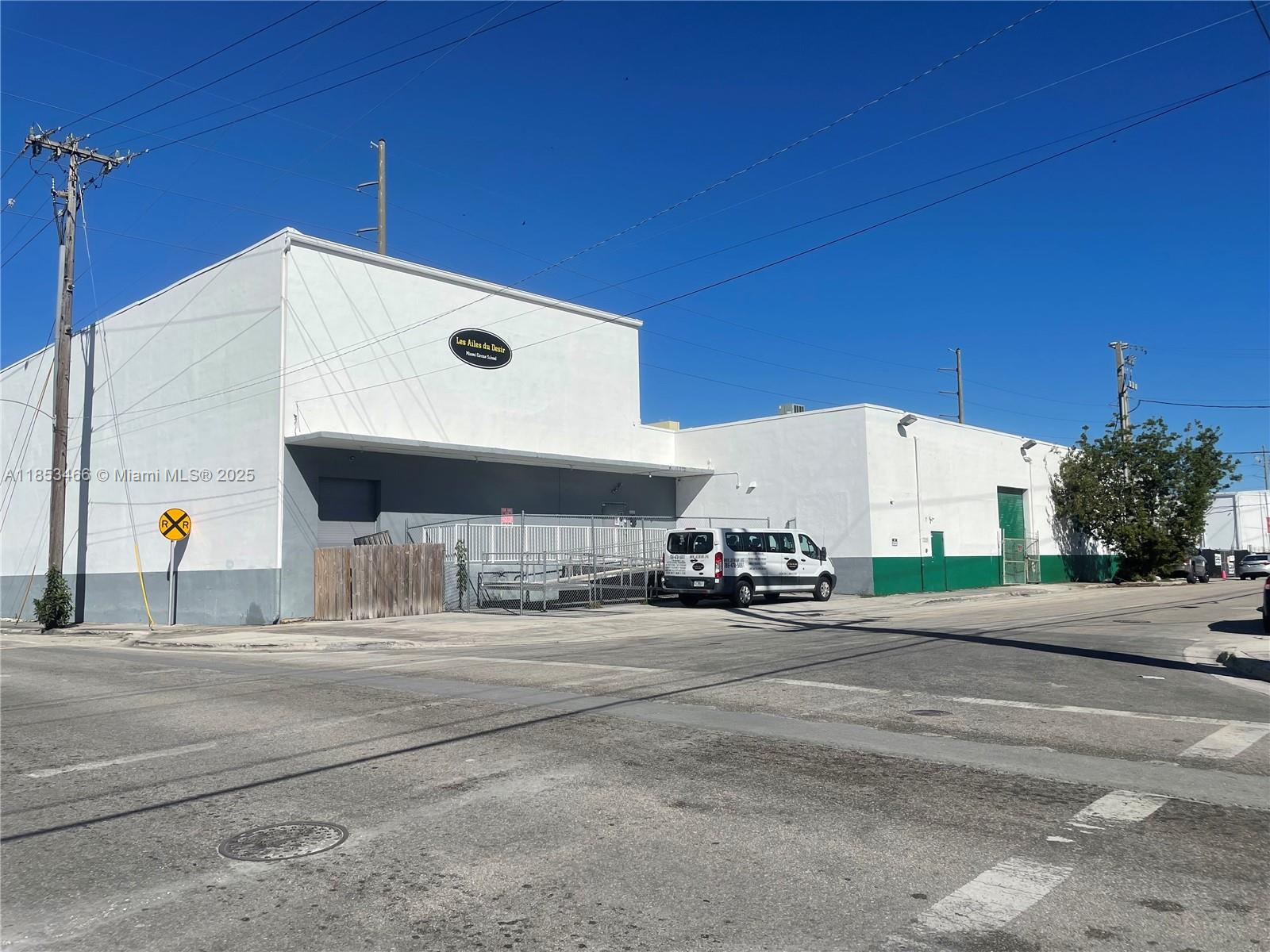 A white commercial building with a loading ramp and a van parked in front — 1395 NW 22nd St, Miami FL 33142, MIAMI, FL