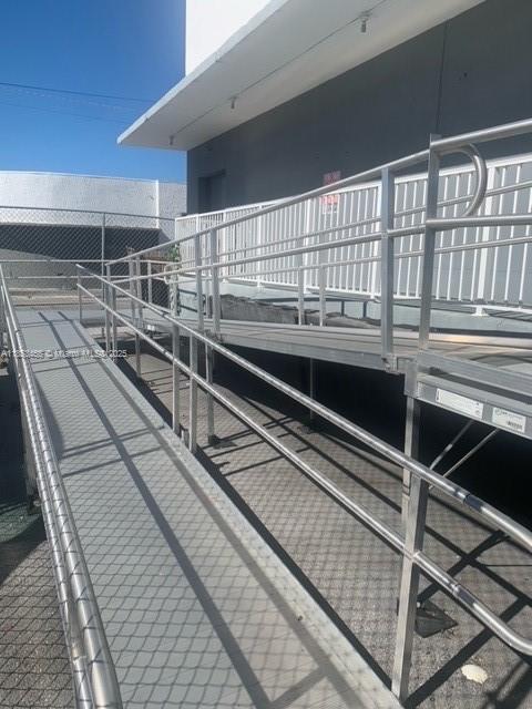 A metal wheelchair ramp with railings leads up to the exterior entrance of a building — 1395 NW 22nd St, Miami FL 33142, MIAMI, FL
