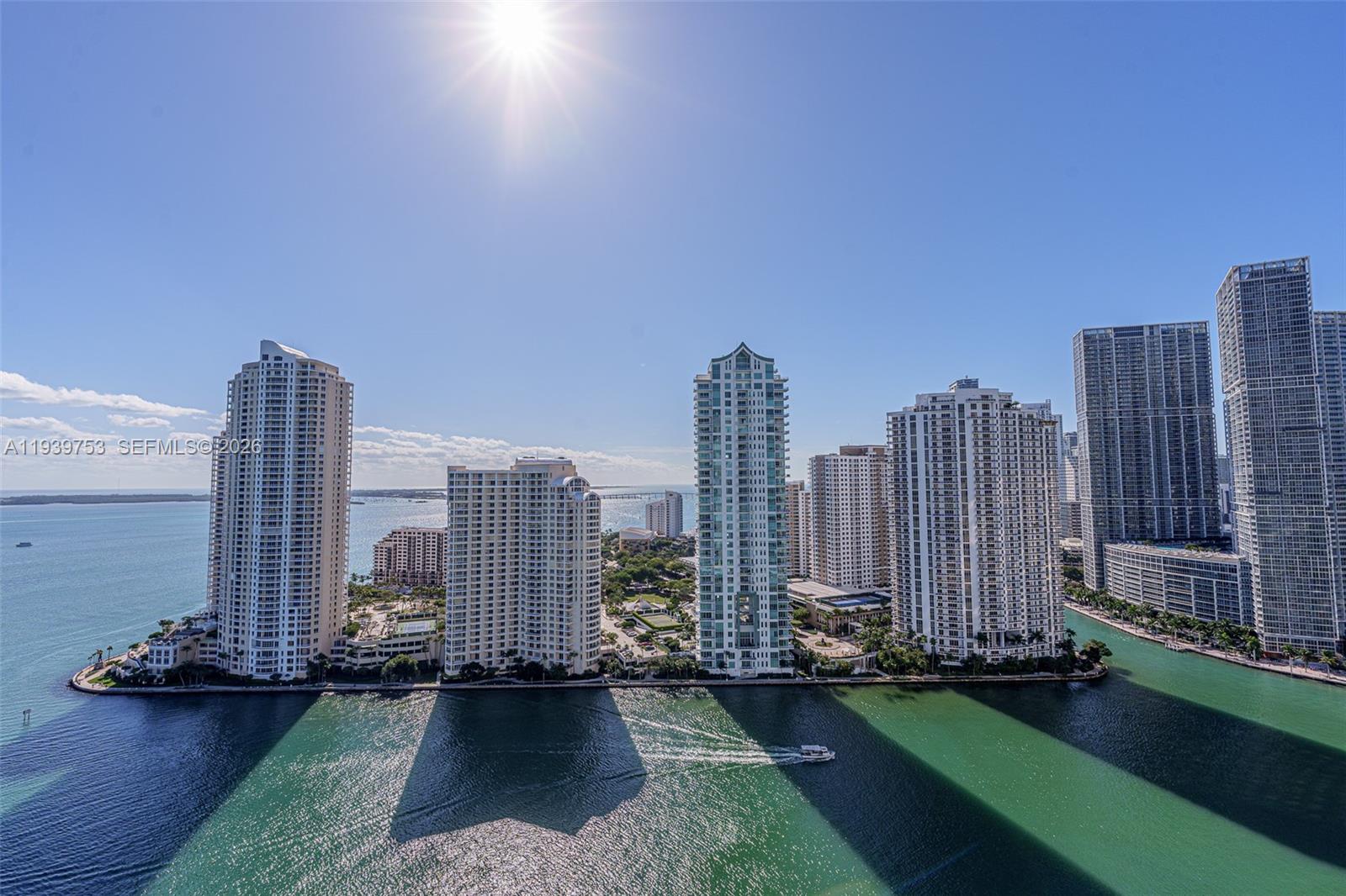 An aerial view shows several high-rise residential buildings situated on a waterfront peninsula — 335 S Biscayne Blvd # 3005, Miami FL 33131, MIAMI, FL