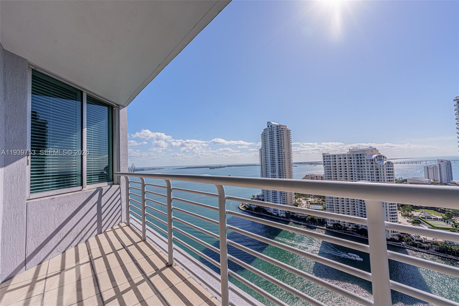 A balcony with a metal railing overlooks a bay and high-rise buildings — 335 S Biscayne Blvd # 3005, Miami FL 33131, MIAMI, FL