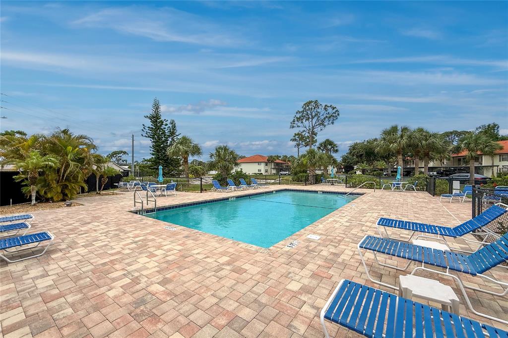 An outdoor swimming pool surrounded by a paved deck and lounge chairs — 118 PINE HOLLOW DRIVE UNIT 118, ENGLEWOOD, FL